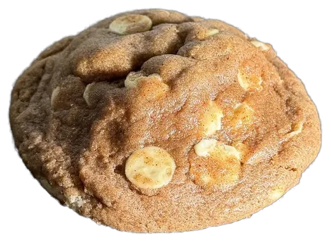 Cookie Ambar inteiro, massa dourada com canela e gotas de chocolate branco; aberto, com o recheio de doce de leite escorrendo
